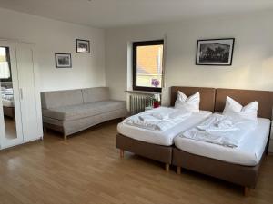 a living room with two beds and a couch at Gasthof Schrätzenstaller in Hettenshausen