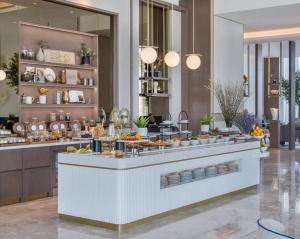 a buffet line with food on it in a restaurant at Address Marassi Residence, Bahrain in Manama