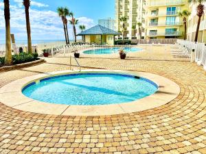 una piccola piscina su una passerella di mattoni vicino alla spiaggia di Beautiful 12th Floor Gulf Front Condo with a Breath Taking View a Orange Beach