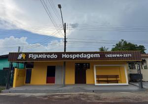 a yellow building with a sign on it at Figueiredo Hosp 4 in Presidente Figueiredo