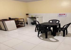 a dining room with a table and chairs and a refrigerator at Figueiredo Hosp 4 in Presidente Figueiredo
