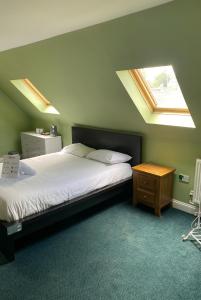 a bedroom with a bed and a table with a window at Halstead Rooms in Halstead