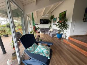 a living room with a couch and a chair at Casa Selva Escondida in Los Altos de Cerro Azul