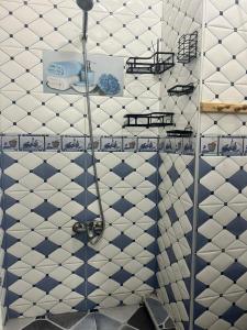 een badkamer met een douche met blauwe en witte tegels bij Casa Youssef 1 in Asilah