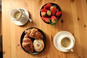 une table avec deux assiettes de pâtisseries et un bol de fraises dans l'établissement Vern Dale Cottage, Erwood, River Wye, Builth Wells, à Builth Wells 12 autres photos