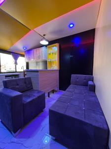 uma sala com sofás e um bar com luzes roxas em Studio de Luxe avec Jacuzzi à 15 Minutes de l'Aéroport AIBD ! em Déni Diarke