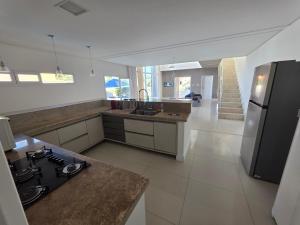 a kitchen with a stainless steel refrigerator and a counter at Refúgio da Praia Aracaju in Aracaju