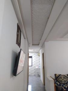 a room with a ceiling with a tv on a wall at appartement en résidence - Bouskoura, Maroc 