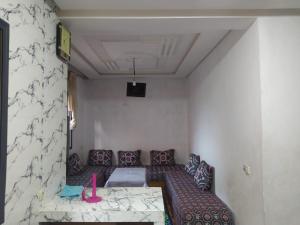 a living room with a couch and a table at appartement en résidence - Bouskoura, Maroc 