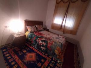 a small bedroom with a bed and a lamp at appartement en résidence - Bouskoura, Maroc 