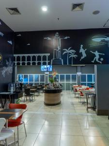 a dining room with tables and chairs and a restaurant at Quality Rio de Janeiro - Barra da Tijuca in Rio de Janeiro