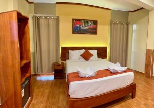 伊基托斯Hotel Yagua的一间带大床和电视的卧室