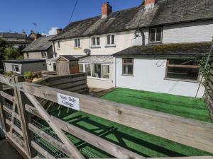 une maison avec un panneau sur une clôture en bois dans l'établissement Vern Dale Cottage, Erwood, River Wye, Builth Wells, à Builth Wells