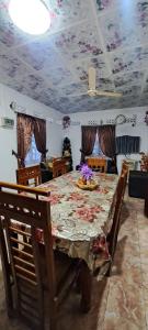 une salle à manger avec une table au plafond fleuri dans l'établissement Shara HomeStay, à Trincomalee