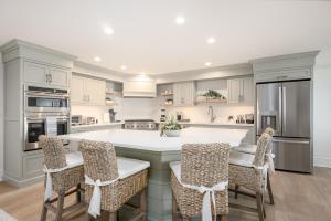 a kitchen with a large white island with chairs at Thomas Sea Suites Penthouses in Plymouth