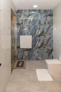 a bathroom with a shower with a marble wall at La Isla Royal - Penthouse Suite in Miches