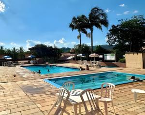 una piscina con sillas y gente en ella en Chalé Encanto, Lazer e Piscinas, en Vinicola Girardi 13 fotos más