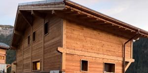 a wooden building with a gambrel roof at Chalet Perle des Alpes in Peisey-Nancroix
