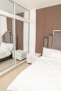 a bedroom with a white bed and a large mirror at La Isla Royal - Penthouse Suite in Miches
