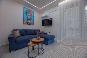 a living room with a blue couch and a table at Aristotelous rooms Nikol in Thessaloniki