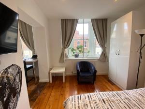 een slaapkamer met een bed, een stoel en een raam bij Heart of Notts, Modern Studio, Great City Views in Nottingham