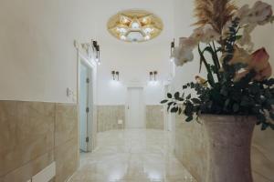un pasillo con un jarrón de flores y una lámpara de araña en Duomo Room Comacchio, en Comacchio 102 fotos más