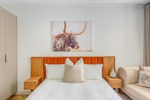 - une chambre dotée d'un lit avec une photo de taureau dans l'établissement One Rosebank CozyCorner, à Johannesbourg
