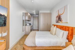 une chambre avec un lit et une cuisine dans l'établissement One Rosebank CozyCorner, à Johannesbourg 4 autres photos