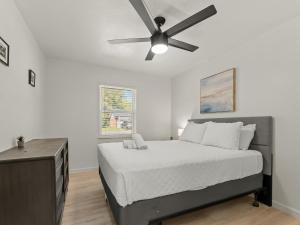une chambre avec un lit avec un ventilateur de plafond dans l'établissement Spacious 4 Bedroom Family Retreat in the Heart of McKinney, TX, à McKinney