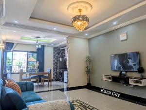 a living room with a blue couch and a tv at KAZA City in Bafoussam