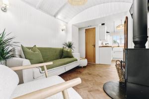 a living room with a green couch and a kitchen at The Willow - Nestled by the green in Arundel
