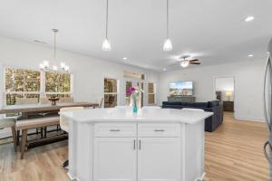 a kitchen and living room with a white island at Munn Hub Live the Dream 4 Bdrm Home with Pool in Pawleys Island