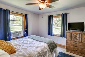 a bedroom with a bed and a flat screen tv at 4 Mi to Lake Michigan Updated Benton Harbor Home! in Benton Harbor