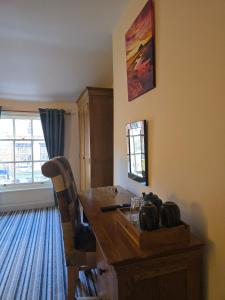 a room with a wooden table with a chair and a window at Honeymoon Suite in Llanidloes