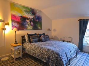 a bedroom with a bed with a painting on the wall at Honeymoon Suite - The Unicorn Hotel in Llanidloes