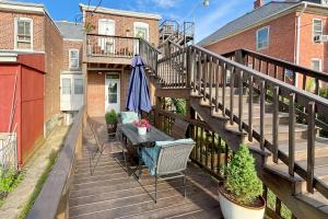 a balcony with a table and an umbrella at Walkable Rental in Dtwn Gettysburg Pet-Friendly! in Gettysburg