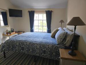 une chambre avec un grand lit et une fenêtre dans l'établissement Cozy Double Room - The Unicorn Hotel, à Llanidloes