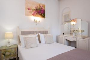 a white bedroom with a bed and a desk at Geronti Moscha Apartment in Apollonia