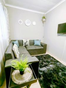 uma sala de estar com um sofá e uma mesa em Zhantique Guest House 2- Unit 8 em Boksburg