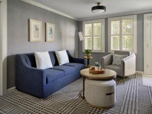 un salon avec un canapé bleu et une chaise dans l'établissement Wequassett Resort and Golf Club, à East Harwich