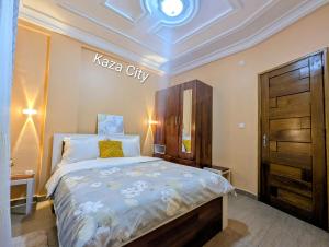 a bedroom with a king sized bed and a wooden door at KAZA City in Bafoussam