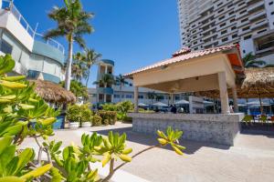 un pabellón en un complejo turístico con palmeras y edificios en Sunset Palace Beach Hotel - All Inclusive, en Mazatlán