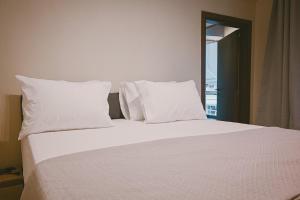 a bed with white sheets and pillows in a bedroom at Downtown Hideaway in Thessaloniki