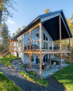 a house with a large deck and a porch at La Belle Vie in Saint Ludger de Milot