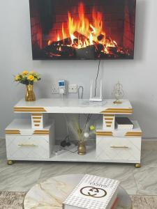 a white desk with a fireplace in the background at Exquisite Homes in Naivasha +8 photos