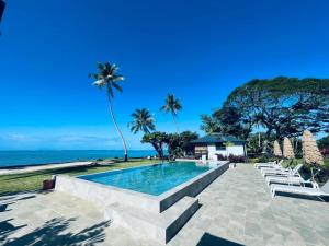 a swimming pool with a view of the ocean at Sublime Tahiti Beach Retreat in Mataiea