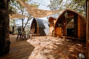 a wooden deck with a tent and a table at Lov'nid 'spa & sauna' in Domme