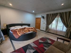 a bedroom with a large bed and a couch at Round Bed Cottage Country Club Resorts Balakot in Pori