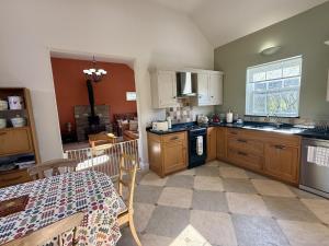 a kitchen with wooden cabinets and a table and a dining room at 2 bed in Whitland 43978 in Whitland