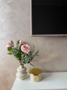 a white vase with pink roses on a table at Kutak mira in Belgrade +15 photos